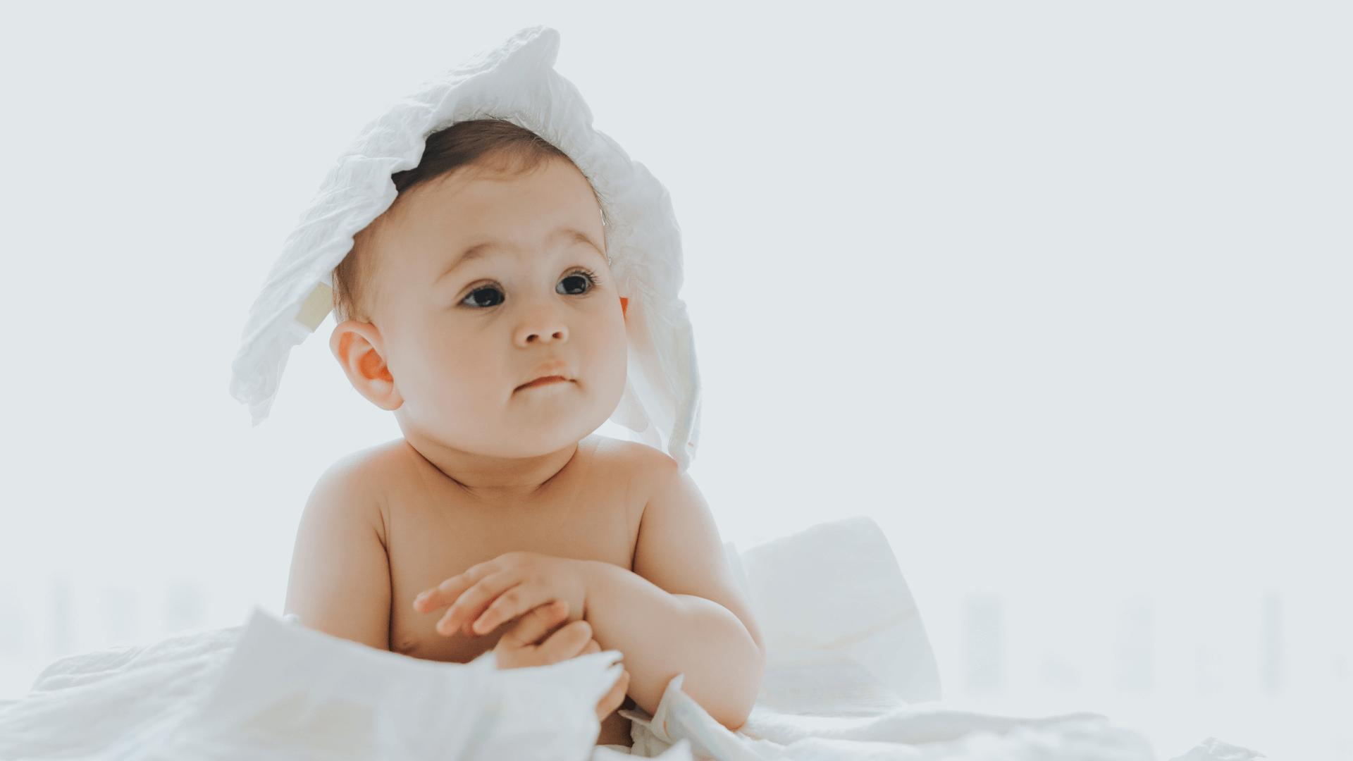 Bambino seduto tra i pannolini