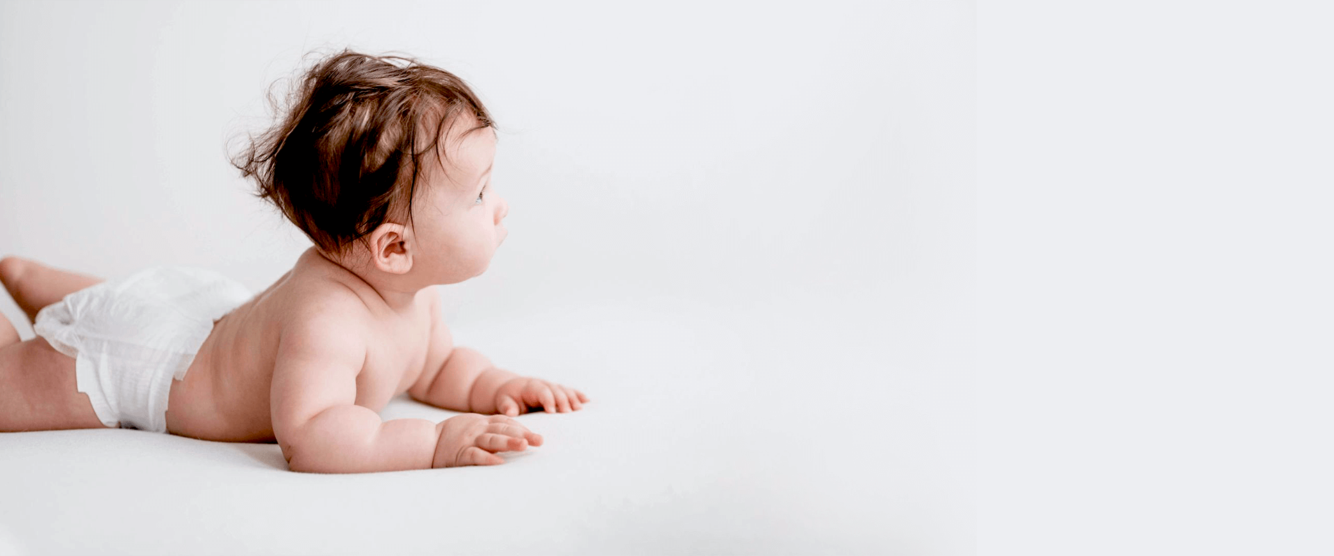 Bambina con pannolino sdraiata a terra